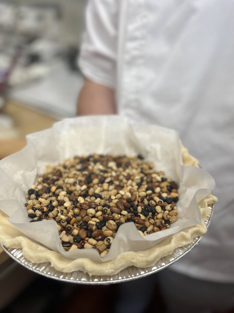 Before pre baking blind bake with parchment paper and beans covering to weight down