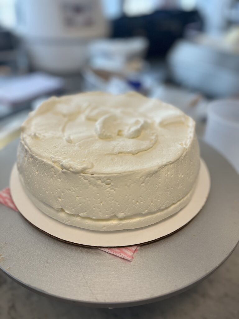 Cake is covered with Italian Buttercream, now leveling and smoothing is necessary.