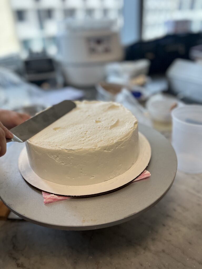 Smoothing the top of the Cake with an offset spatula.